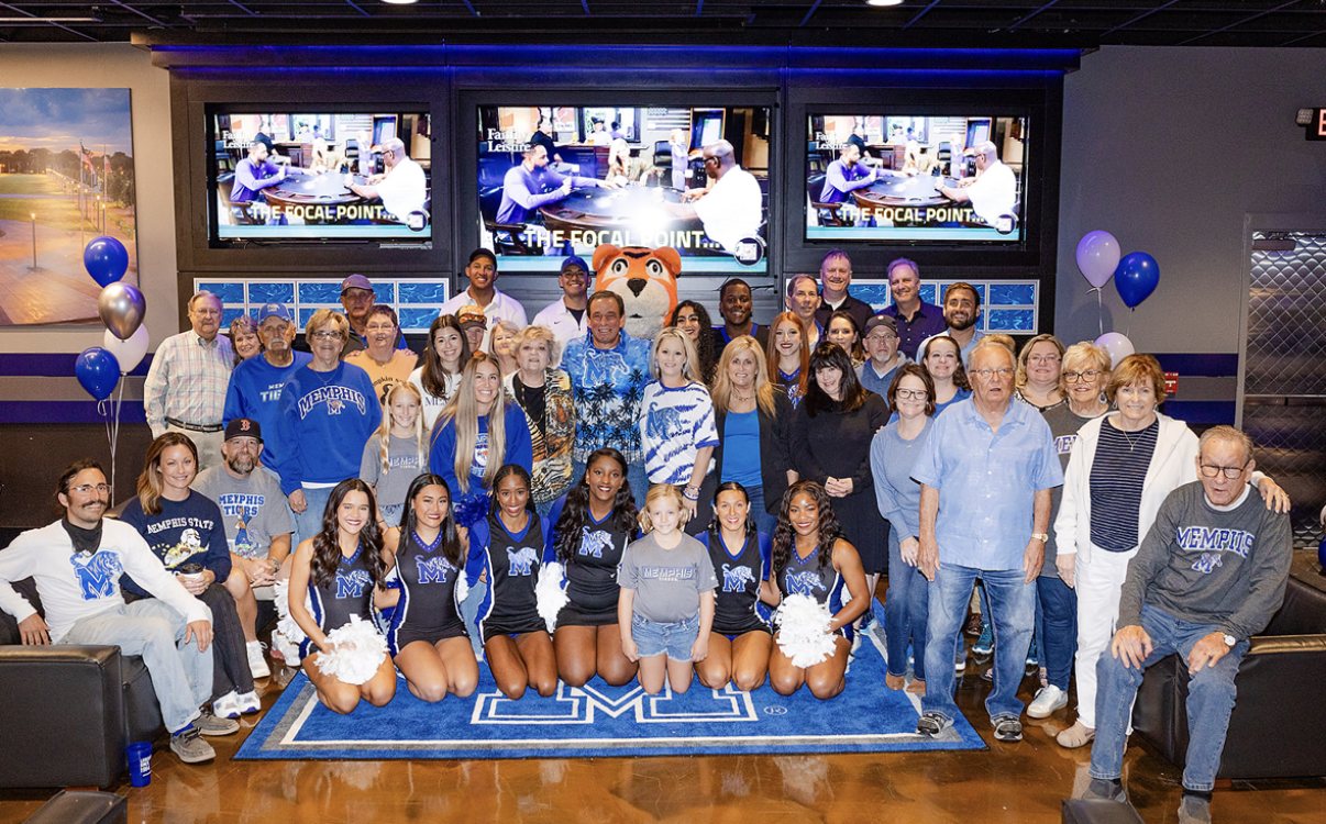 Family and friends in Tigers blue with the mascot and the spirit squad kneeling on a Memphis M rug